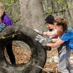 Dívky valí pneumatiku odhozenu v přírodě