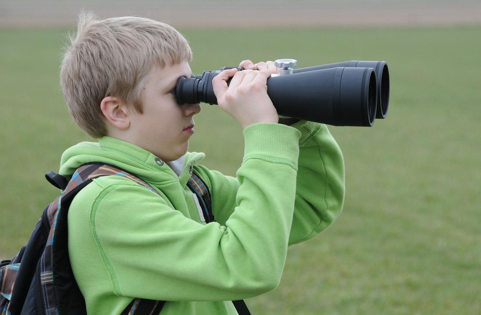 Chlapec pozoruje dalekohledem vzdálený objekt